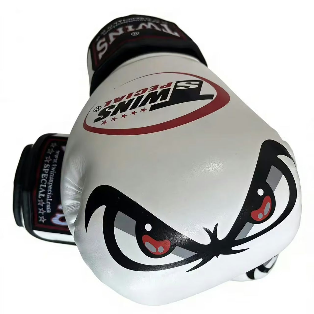 A pair of Twins Special boxing gloves, featuring a white body with a black and red graphic of an angry face on the front glove, and black wrist straps with white branding.