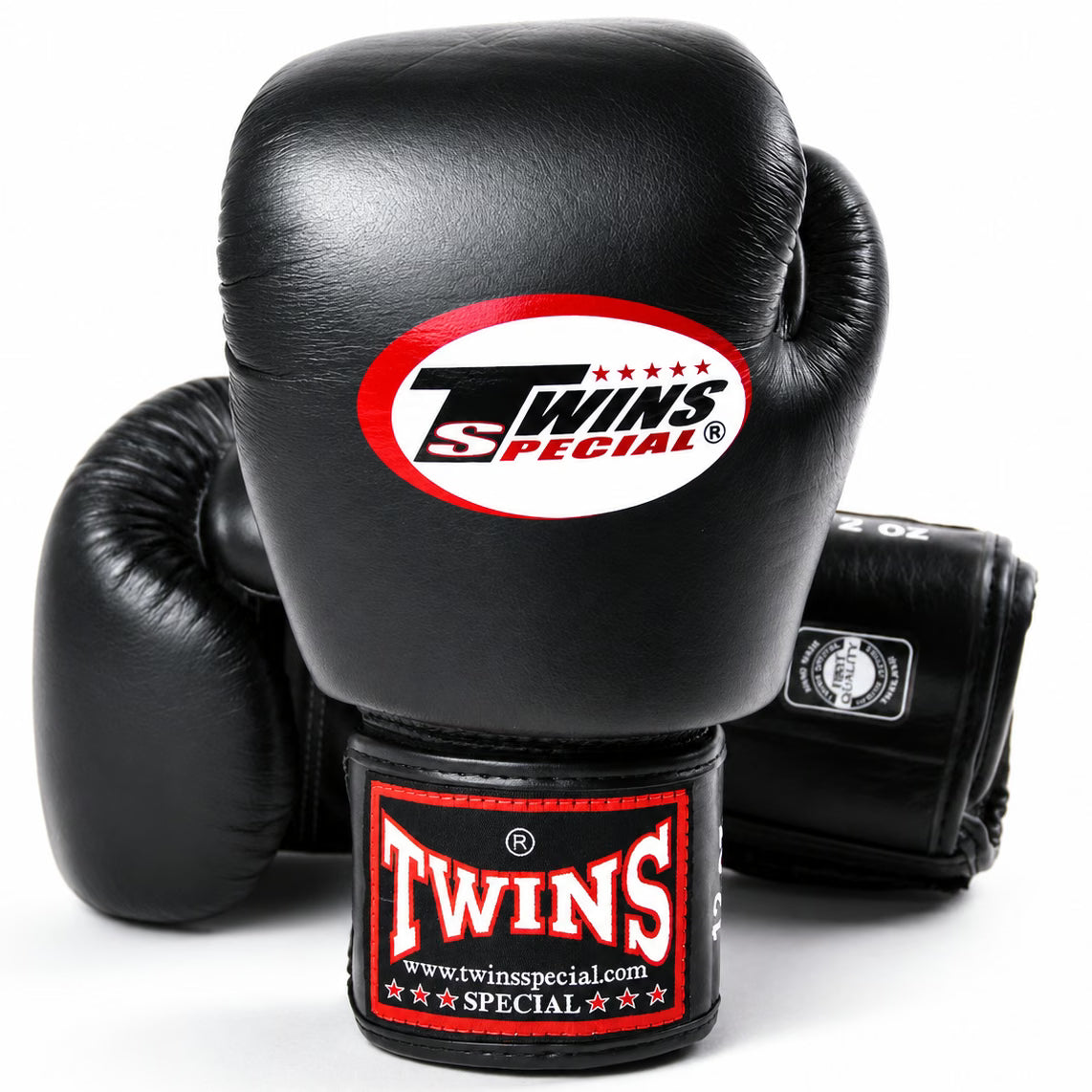 Three black leather boxing gloves, with one prominently displayed in the foreground showing the Twins Special logo on the knuckle and wrist strap, set against a clean white background.