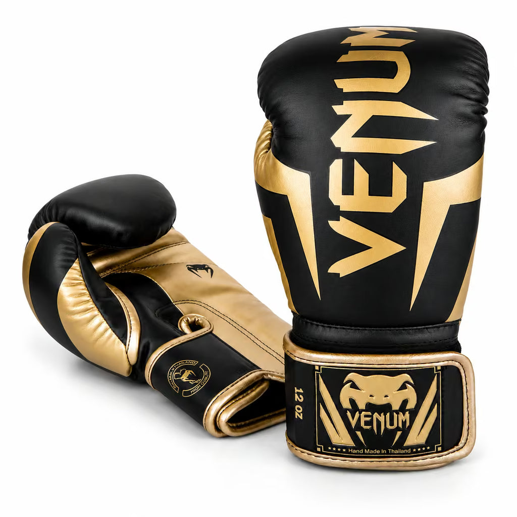 A pair of Venum boxing gloves in black and gold, displayed on a clean white background. One glove is positioned upright to show the front with the large gold Venum logo, and the other is angled to show the back and wrist strap with the Venum brand patch.