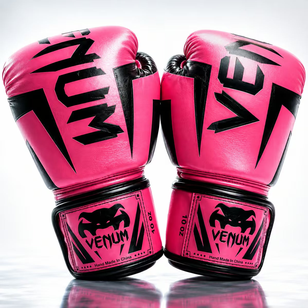 Pair of pink boxing gloves with Venum branding on a white background