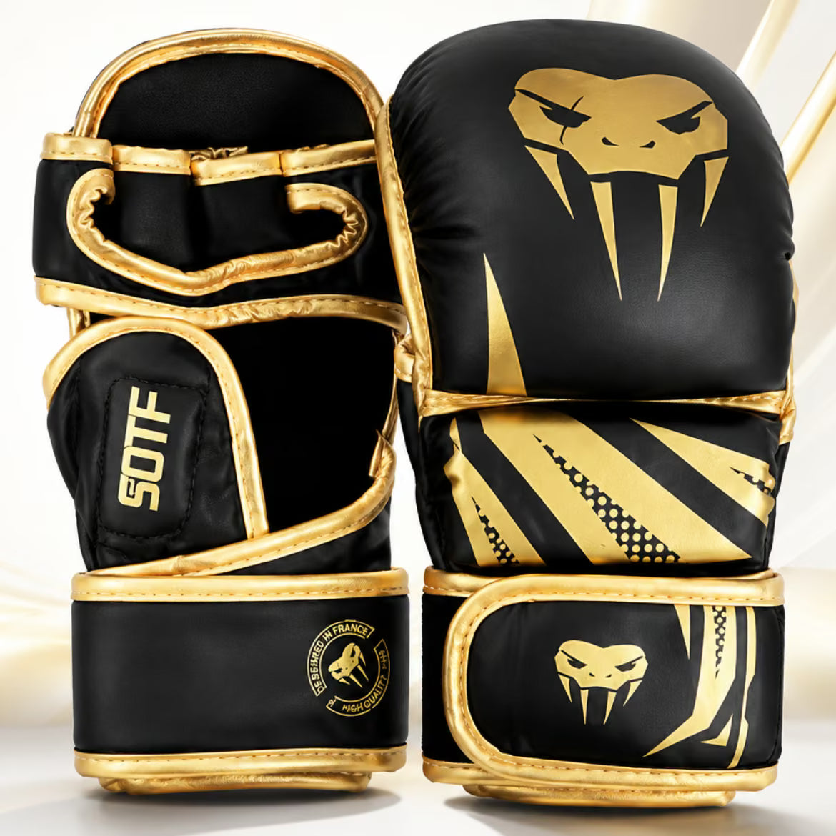 A pair of black and gold MMA gloves with a snake head logo, shown on a clean white background.