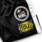 Black and white boxing shorts with multiple brand patches, including DAZN, WBC, Golden Boy, and Everlast, on a white background.