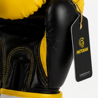 A pair of Pretorian boxing gloves in yellow and black, shown against a light gray background with promotional text and care instructions. The gloves feature a bold black logo and branding, and the image includes text detailing the product options and care guidelines.
